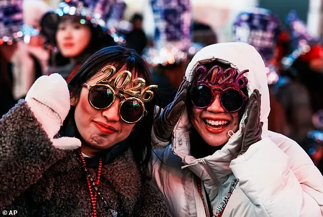 Glowing in the Cold: Times Square Revelers Celebrate New Year's Eve with Novelty Glasses and Unyielding Spirit